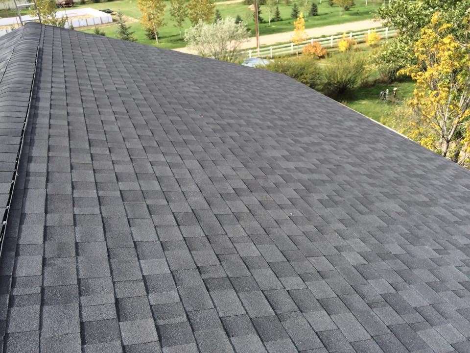 Aerial view of dark gray roof with rural landscape